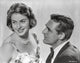 Indiscreet Couple Photo Print featuring a lady in a printed dress and a man in a suit.