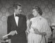 Indiscreet photo print of a man and woman facing each other.