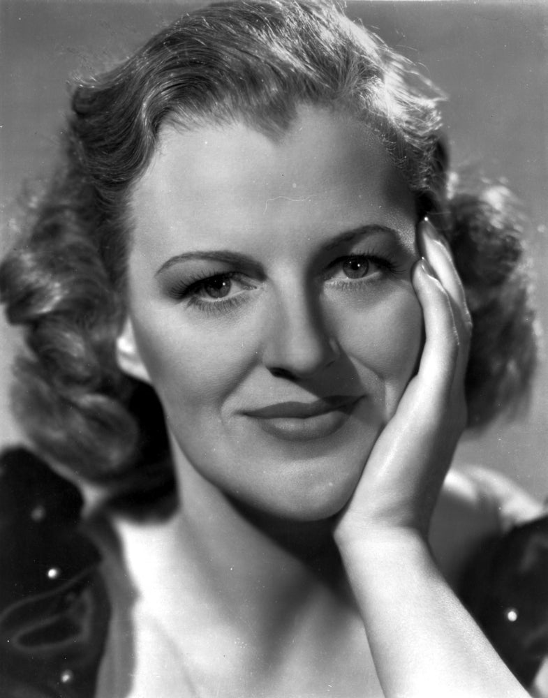 Gracie Fields photo print in puff-sleeve top with hand on face.