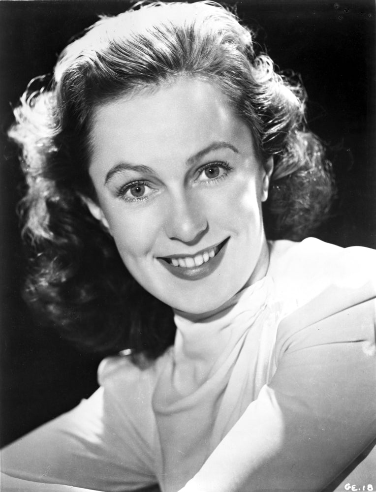 Geraldine Fitzgerald smiling portrait photo print in long sleeve top.