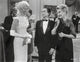 Pillow Talk scene photo print of people in formal outfits engaged in conversation.