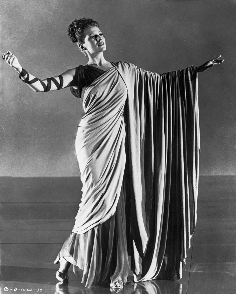Rita Hayworth striking a pose in an elegant Roman gown photo print.