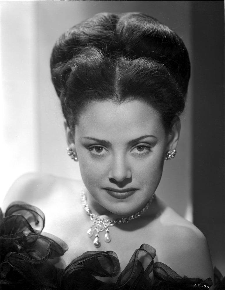 Carol Forman in a ruffled lace gown with necklace and earrings photo print.