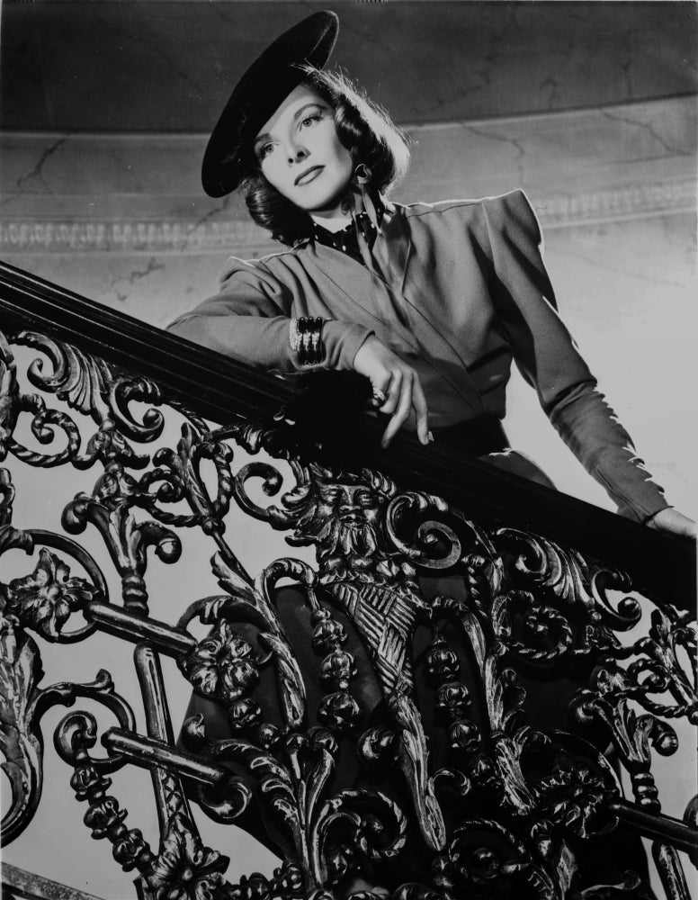 Katharine Hepburn posed on stairs in a dress and hat photo print.