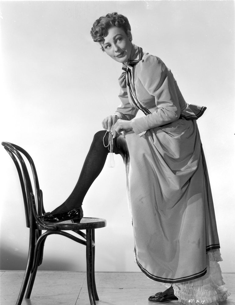 Virginia Grey photo print of woman fitting in her stockings on chair.