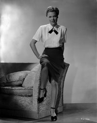 Joan Harrison in a formal dress sitting on an armrest, photo print.