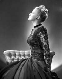 Martha Holliday sitting on a couch in an embroidered dress - photo print