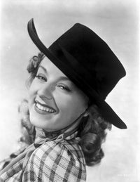 Jennifer Holt smiling portrait photo print in checkered top and hat.
