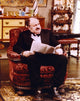 Lou Jacobi sitting in chair with newspaper photo print