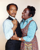 Jeffersons photo print featuring a man in black vest suit and a woman in blue long sleeve dress.