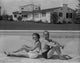 A Couple Sitting on the Side of the Pool Photo Print