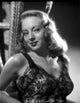 Evelyn Keyes smiling photo print wearing an embroidered top.