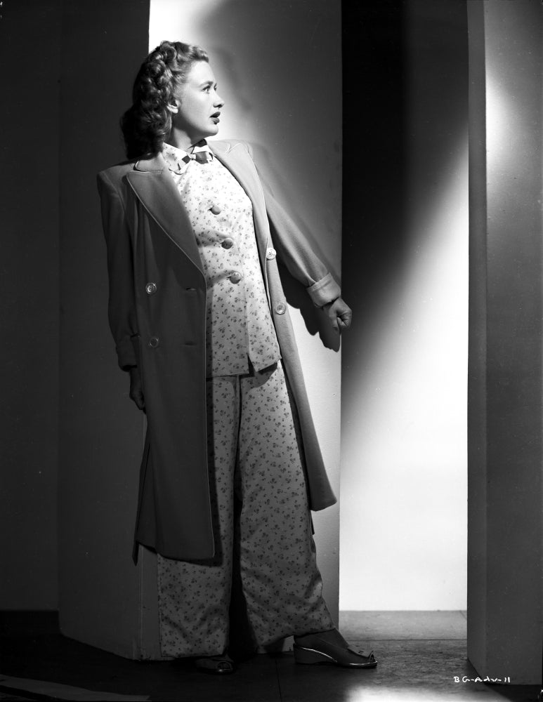 Priscilla Lane leaning on wall in elegant dress and coat photo print