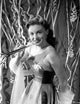 Joan Leslie smiling and posed in a stunning dress photo print.