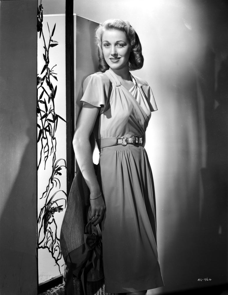 Audrey Long leaning and smiling in a silk dress photo print.