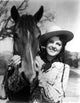 Fay McKenzie smiling with a horse photo print.