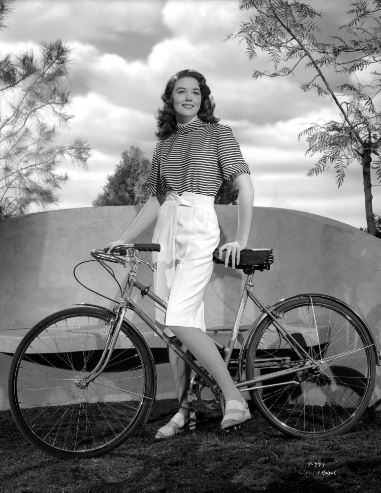 Dorothy Malone on a printed top holding a bicycle photo print