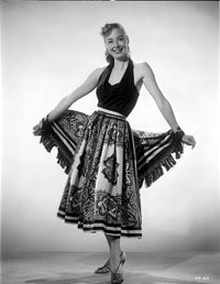 Adele Mara posed and smiling in a stylish printed skirt photo print.