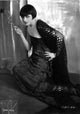 Pola Negri kneeling on floor in embroidered dress photo print.