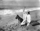 Pola Negri sitting on sand with a dog photo print.