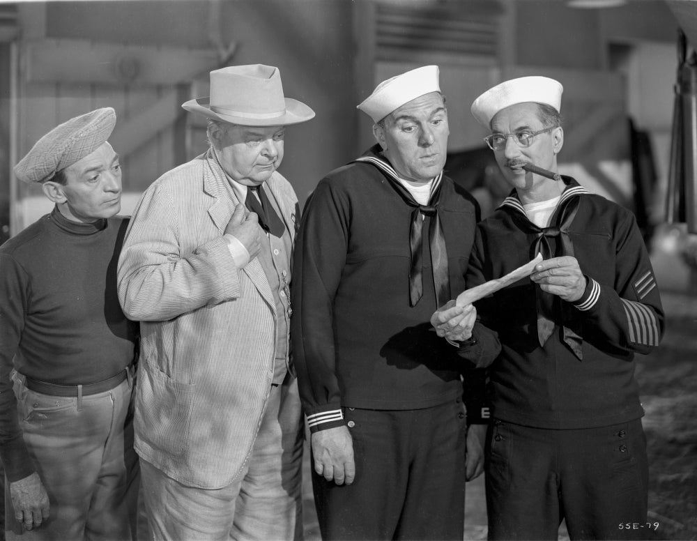 Girl In Every Port Photo Print featuring four men reading a newspaper.