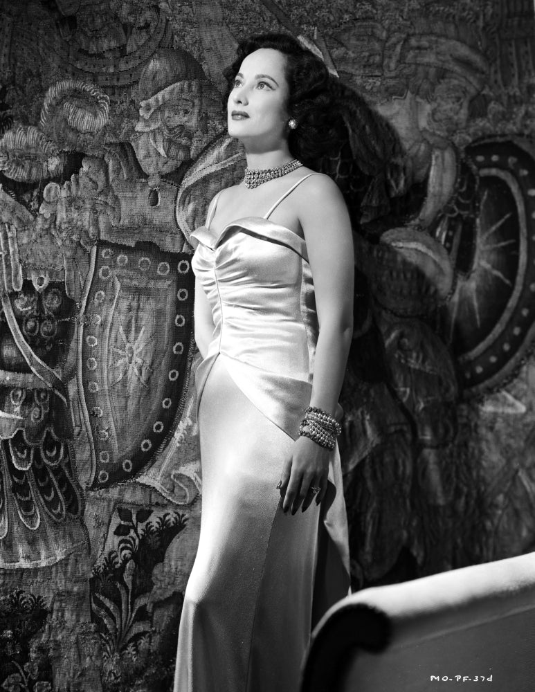 Merle Oberon standing elegantly in a silk gown photo print.