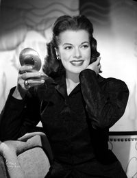 Janis Paige photo print sitting on a couch holding a mirror.