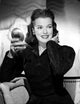 Janis Paige photo print sitting on a couch holding a mirror.