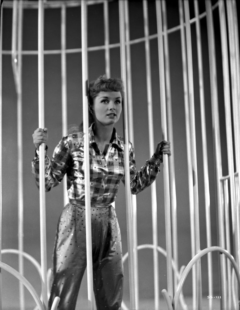 Debbie Reynolds standing behind bars in plaid sleeves photo print.