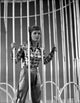 Debbie Reynolds standing behind bars in plaid sleeves photo print.