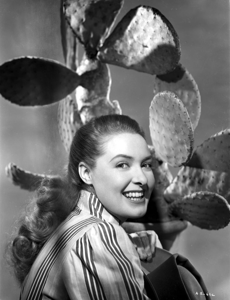 Ann Richards smiling below a cactus classic photo print.