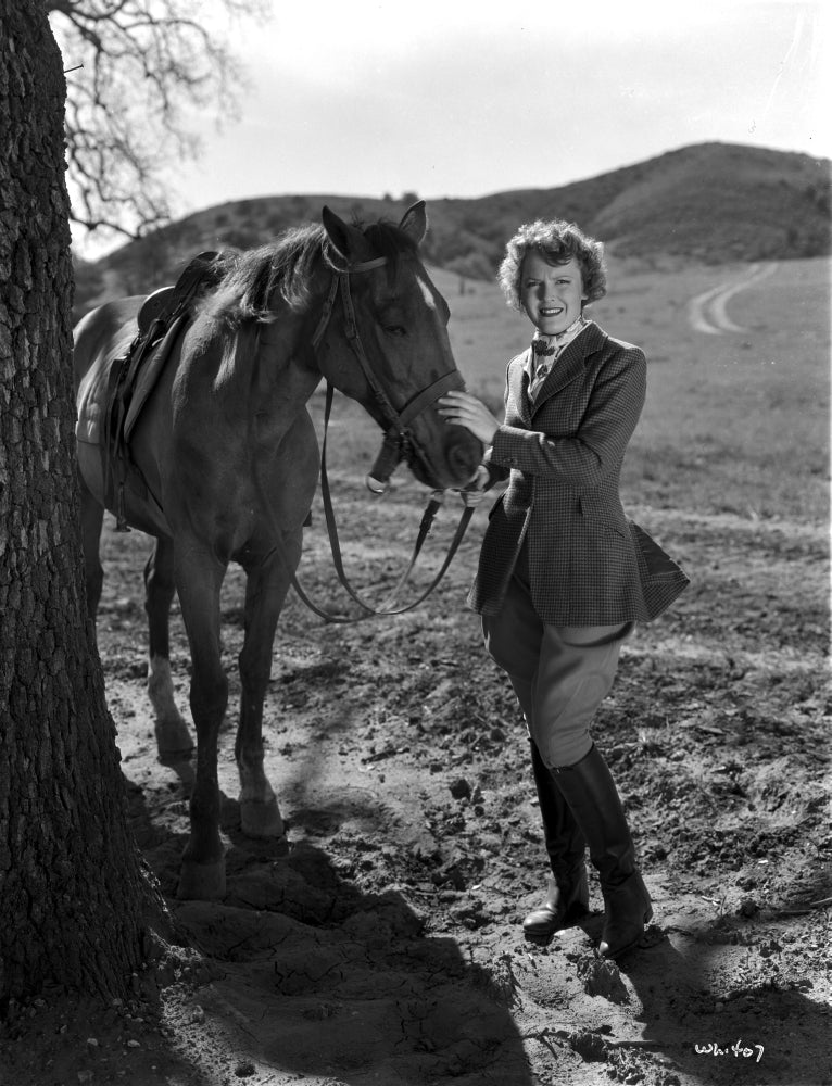Beverly Roberts holding a horse photo print, showcasing the bond between human and animal.