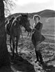 Beverly Roberts holding a horse photo print, showcasing the bond between human and animal.