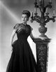 Ann Sheridan photo print in a black dress holding a lamp