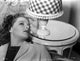 Ann Sheridan leaning on a chair near a lamp shade photo print