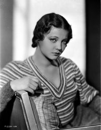 Sylvia Sidney seated on couch in a printed knitted sweater photo print