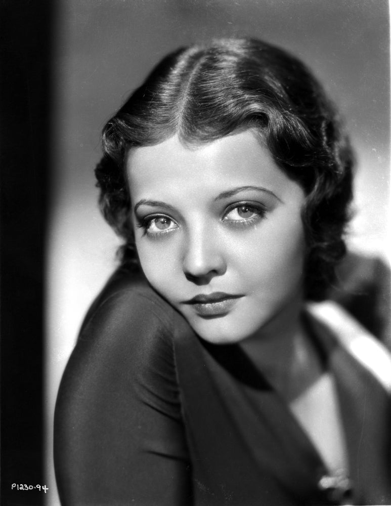 Photo print of Sylvia Sidney posed in a long sleeve blouse.