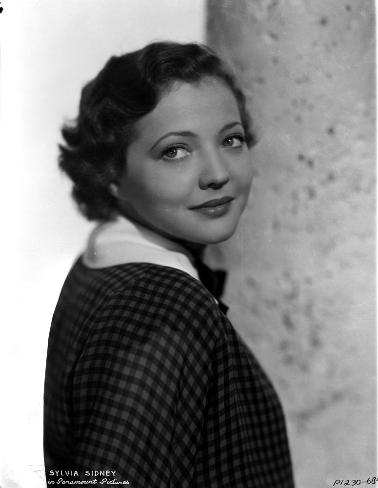 Photo print of Sylvia Sidney posed in checkered blouse.
