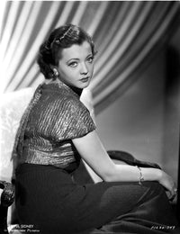 Photo print of Sylvia Sidney in a black skirt and shining blouse, vintage fashion.