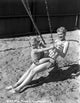 Penny Singleton swing riding with her son at the beach photo print.