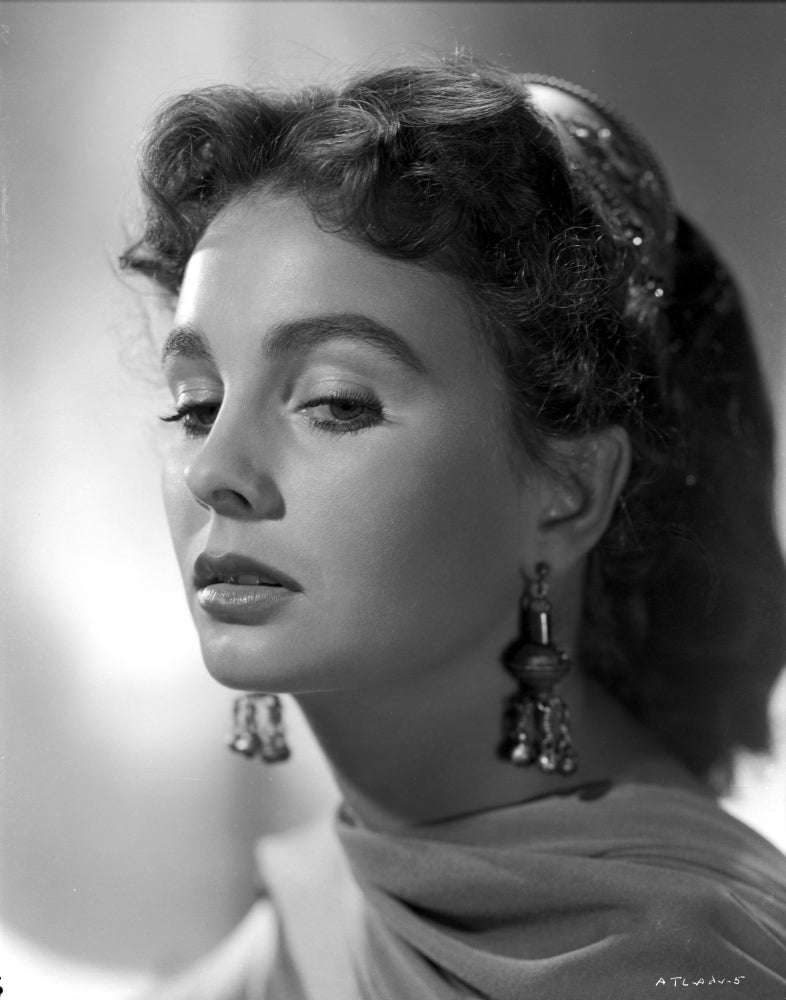 Close-up portrait of Jean Simmons wearing a silk scarf and dangling earrings.