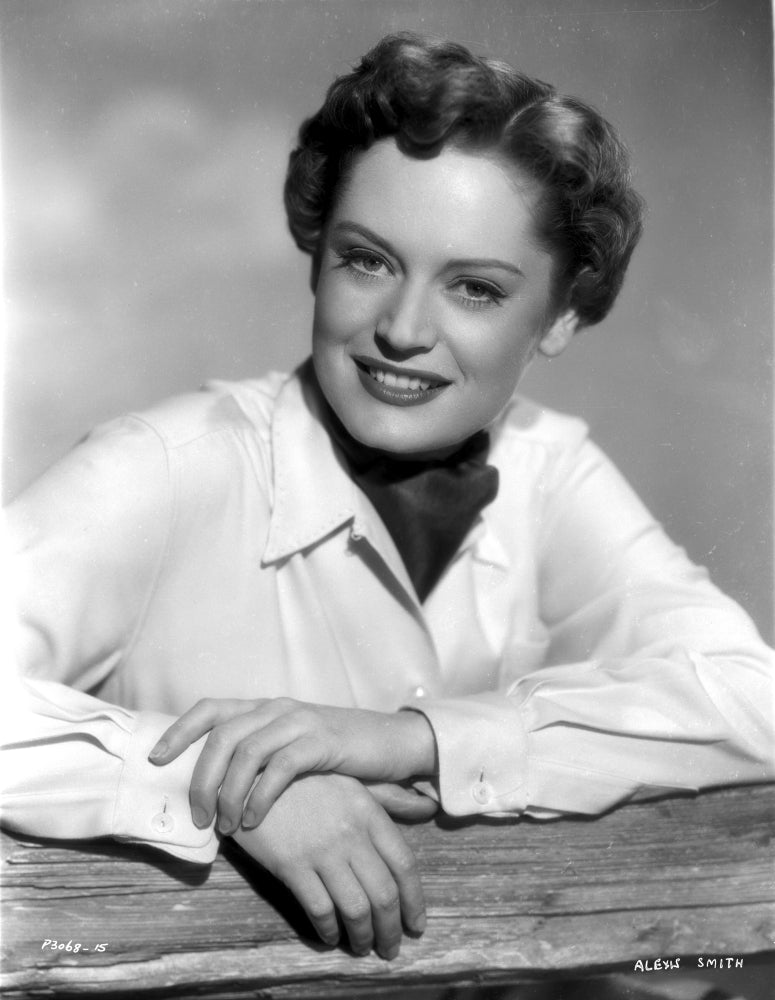 Alexis Smith leaning on a fence wearing white long sleeves photo print.