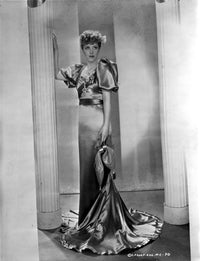 Betty Stockfeld standing in an elegant glossy gown photo print.
