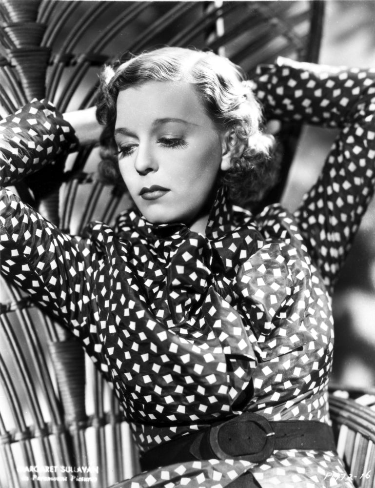 Margaret Sullivan in polka dot outfit, photo print raising both hands.