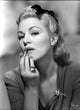 Claire Trevor putting lipstick in dress photo print.