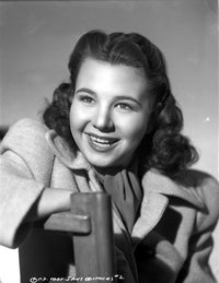 Jane Withers seated in a grey linen tweed coat photo print.