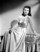 Jane Wyatt seated on a couch in a white silk dress photo print
