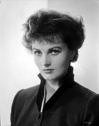 Ursula Theiss photo print staring intently into the camera, wearing a high-neck ensemble.