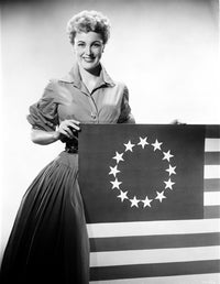 Jan Sterling photo print in velvet dress and pleated skirt holding a flag