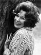 Shirley MacLaine leaning and smiling on a tree photo print